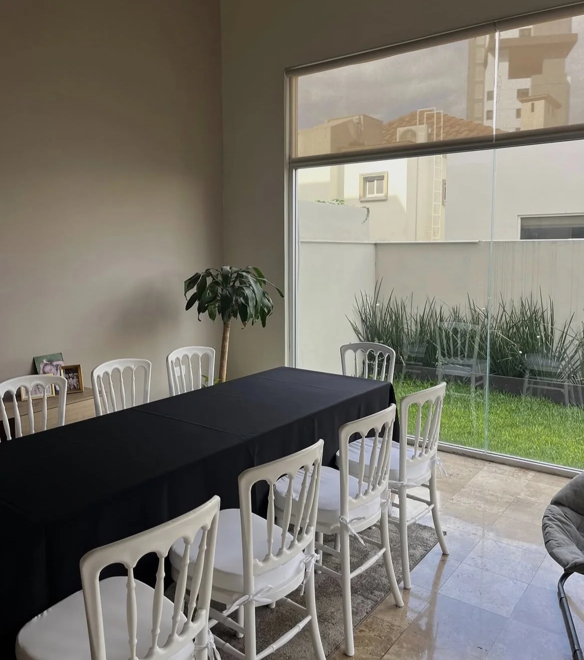 Mesa rectangular con mantel negro y sillas blancas